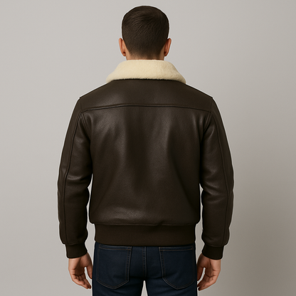 Man wearing a brown leather jacket with a cream collar against a gray background